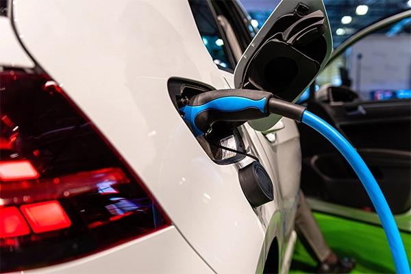 Close-up of an electric vehicle plugged into a power supply being charged.