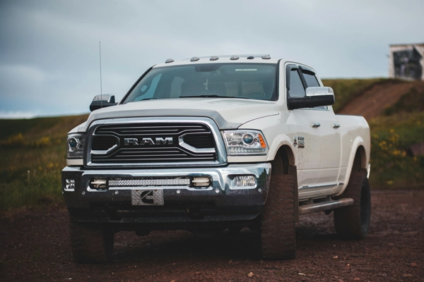 A white Dodge Ram parked in a dirt field 