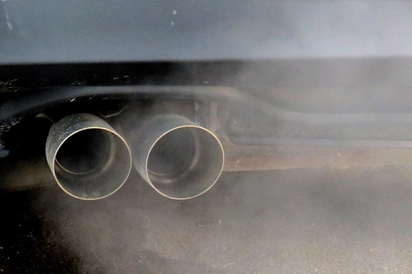 close-up look at a vehicles exhaust emitting smoke
